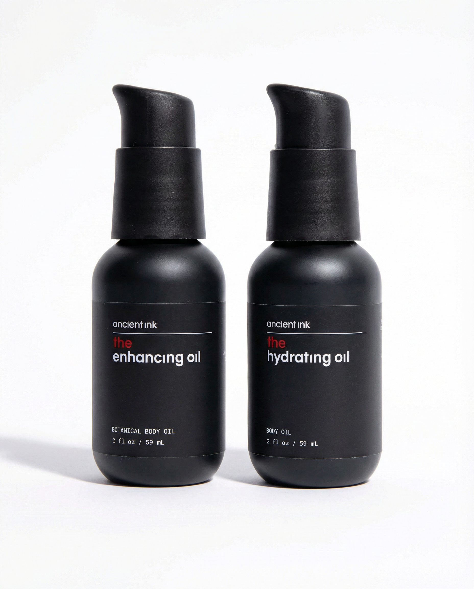 Two black bottles of 'ancient ink' enhancing and hydrating oils on a white background