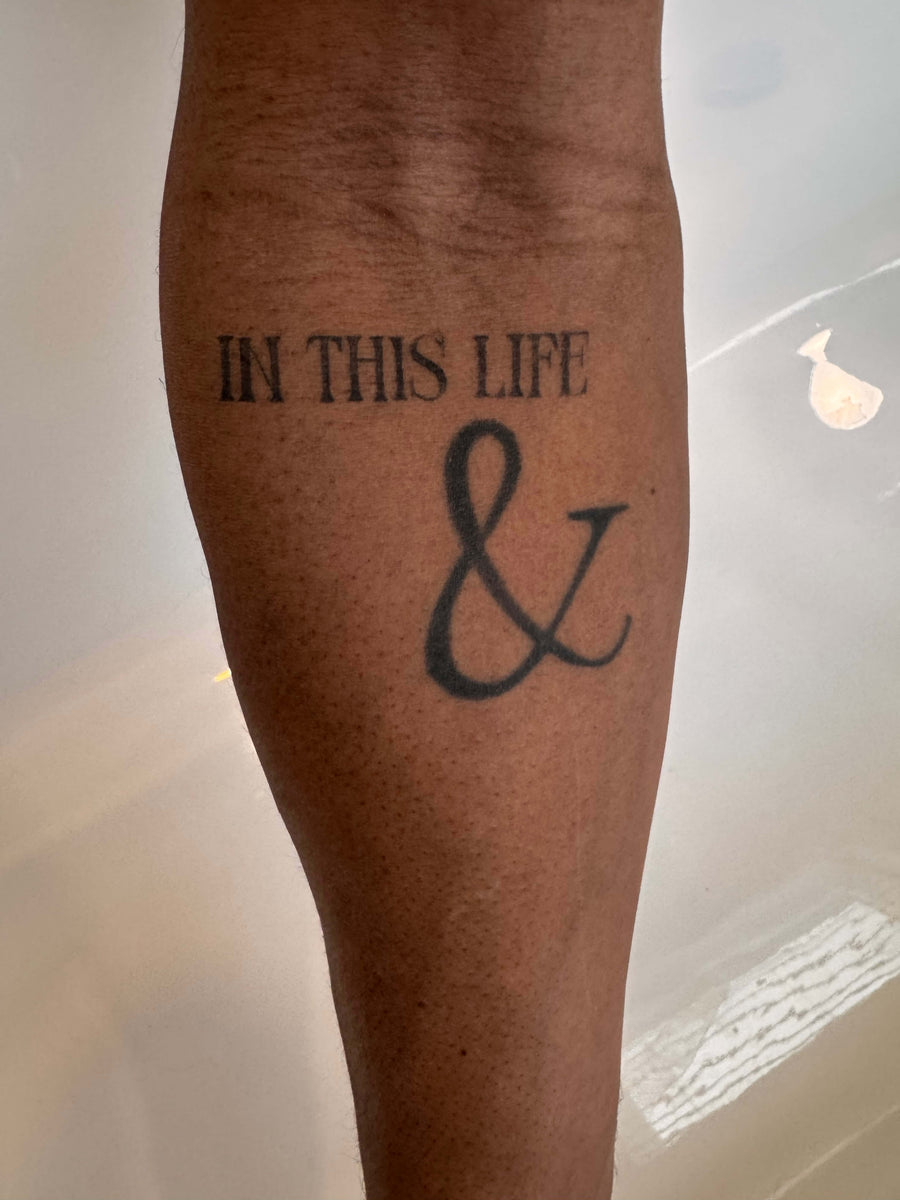 Close detail of a lettering tattoo carried on a forearm