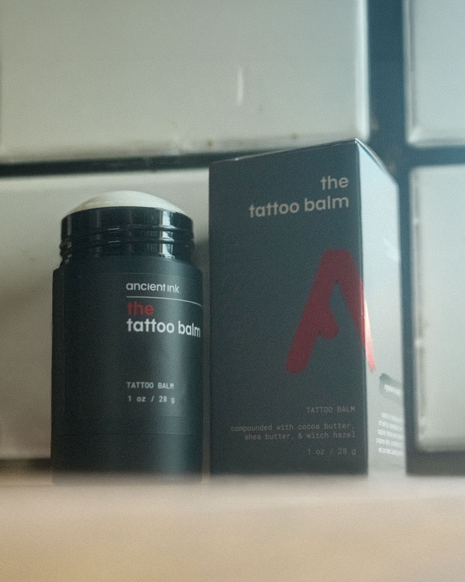 tattoo balm product image with a wood foreground and subway tile background